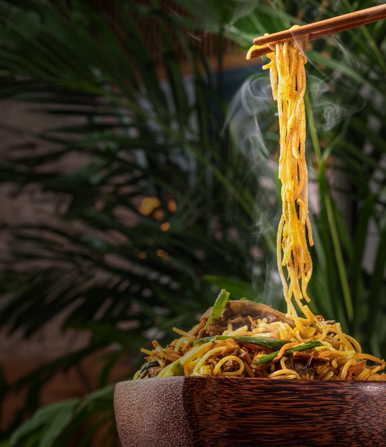 Brya Zan stir-fried noodles lifted steaming with chopsticks